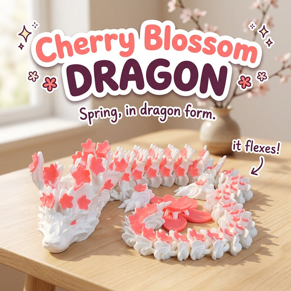 Cherry Blossom Dragon 3D printed articulated flexi toy by Cosmic 3D Creations, on a light wood table with a cherry blossom branch