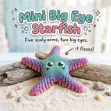Mini Big Eye Starfish 3D printed articulated flexi toy by Cosmic 3D Creations, on sand with driftwood and shells