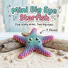 Mini Big Eye Starfish 3D printed articulated flexi toy by Cosmic 3D Creations, on sand with driftwood and shells