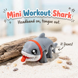 Mini Workout Shark 3D printed articulated flexi toy by Cosmic 3D Creations, on sand with driftwood and shells