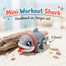 Mini Workout Shark 3D printed articulated flexi toy by Cosmic 3D Creations, on sand with driftwood and shells
