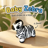 Baby Zebra 3D printed articulated flexi toy, on a sunlit table with tropical leaves