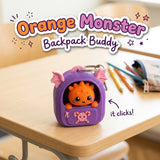 Orange Monster Backpack Buddy 3D printed clicker fidget keychain on a school desk