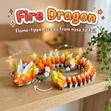 Fire Dragon 3D printed articulated flexi toy by Cosmic 3D Creations, on a cozy shelf with fairy lights