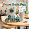 Name Desk Sign 3D printed personalized standing sign with the sample name Ava in leopard print by Cosmic 3D Creations, on a cafe table