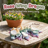 Rose Wing Dragon 3D printed articulated flexi toy by Cosmic 3D Creations, on a sunny garden table with flowers
