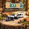Skunk 3D printed articulated flexi toy by Cosmic 3D Creations, on a tree stump with moss and pine cones