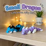 Small Dragon 3D printed articulated flexi toy by Cosmic 3D Creations, on a cozy shelf with fairy lights